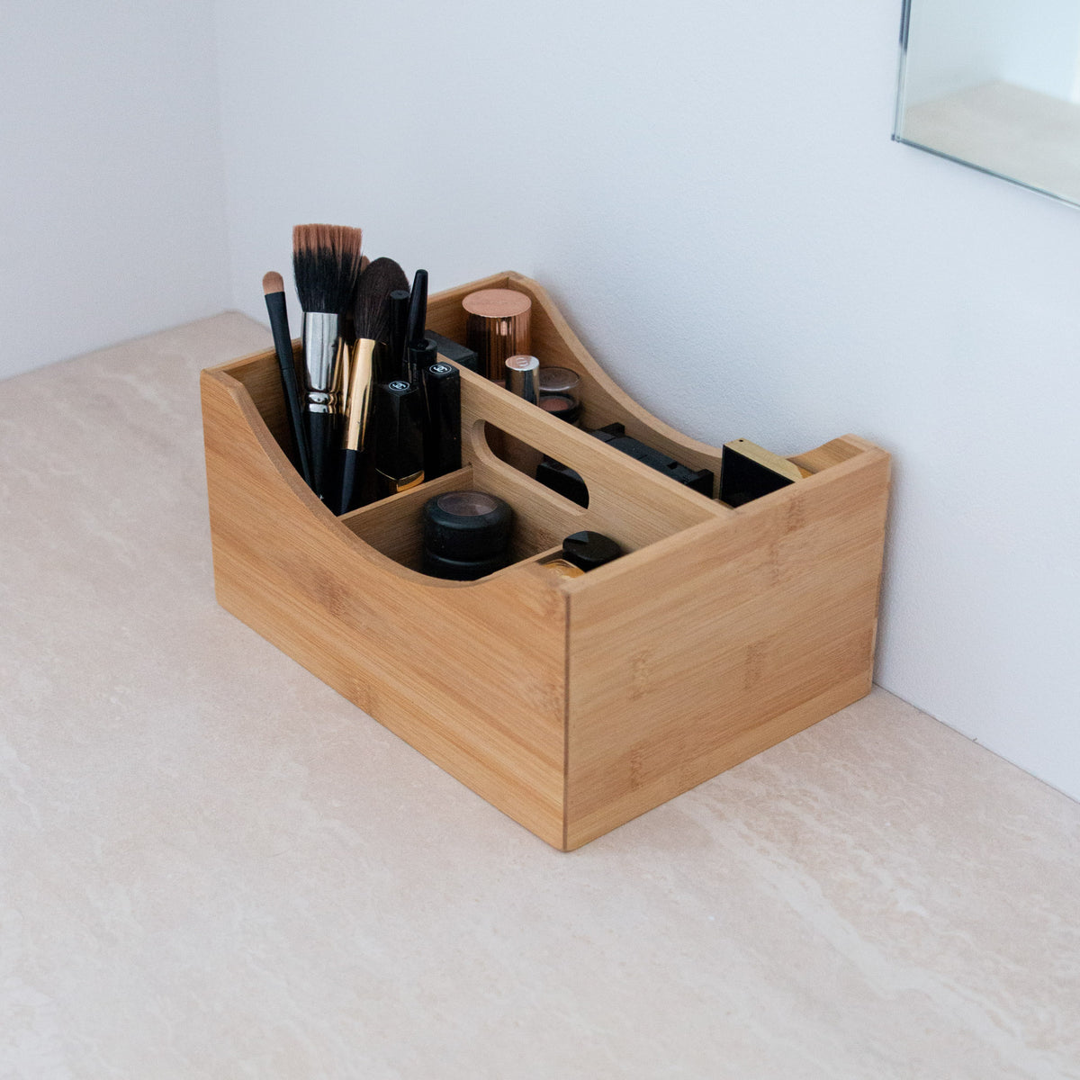 Makeup organizer med hank – fyldt med makeup og vist med bærehank